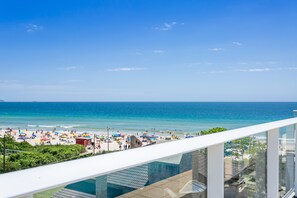 En balkon med udsigt over en strand og et hav.