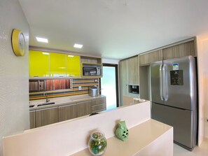 Uma cozinha moderna com geladeira de aço inoxidável, micro-ondas e torradeira.