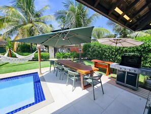 An outdoor patio with a pool, a barbecue grill, and a hammock. - Lindos Bangalôs - Carneiros Beach Resort (Tamandaré)