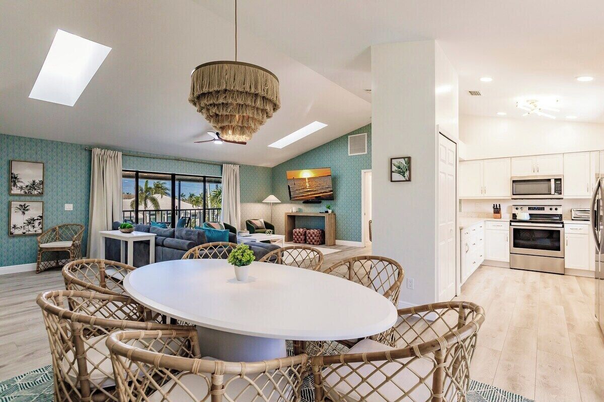 Uma sala de estar moderna com área de jantar, cozinha e janelas amplas com vista.