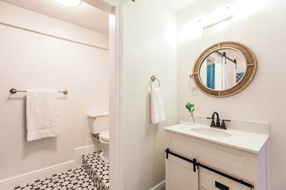 Ein Badezimmer mit Toilette, Waschbecken, Spiegel und Handtuchhalter.