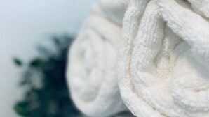 A stack of white towels on a shelf.