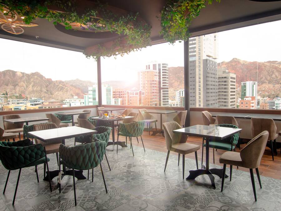 A restaurant with a terrace overlooking a cityscape and mountains.