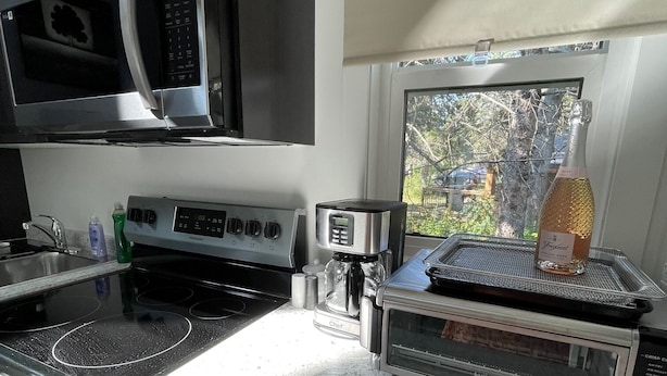 A kitchen with a microwave, toaster, and oven. - The Cottages @Gull&Castle#6 (Wasagaming)