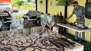 A restaurant with a table set for a meal, a laptop on the table, and a person standing nearby.