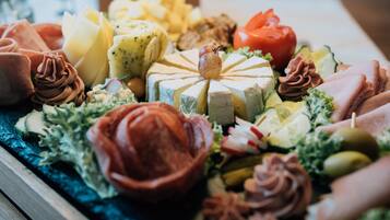 Un assortiment de fromages, de charcuteries et de garnitures présentés sur un plateau.