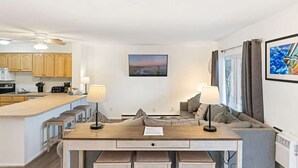 A modern living space with a kitchen, dining area, and seating area.