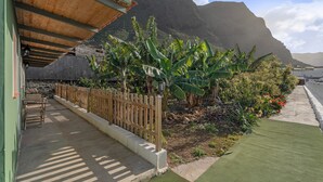 Un espace patio agrémenté d’une clôture en bois, d’un chemin en béton et d’une section de gazon synthétique.