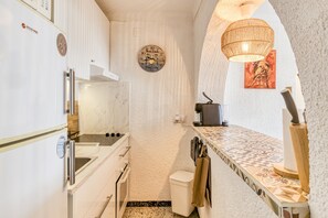 A compact kitchen with a built-in oven, a sink, and a microwave.