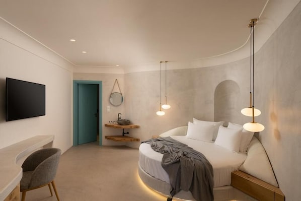 A modern bedroom with a bed, bedside table, TV, and a unique wall arch.