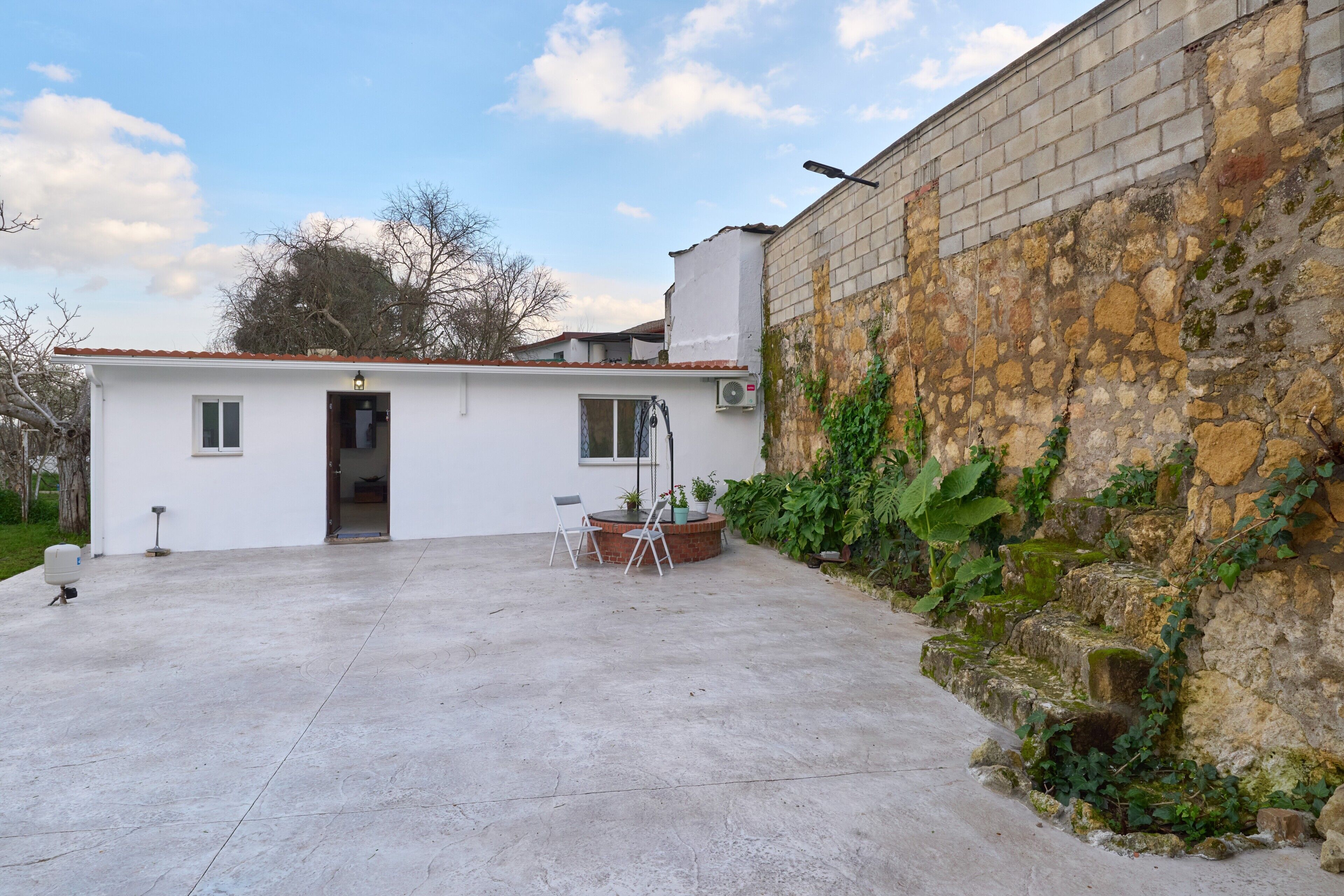 Un petit bâtiment d’un seul étage, doté d’un toit plat, d’une terrasse en béton et d’un mur en briques.