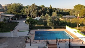 Una piscina con vista su alberi e un edificio sullo sfondo.