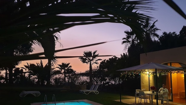A swimming pool with a lounge area, palm trees, and a sunset view. - Apartment 'Villa Colliure' with Sea View, Private Pool and Wi-Fi (Adeje)