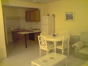 A compact living space with a dining area, kitchen, and seating area.