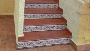 Una escalera con baldosas decorativas que conduce a un rellano.