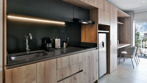 Une cuisine moderne avec des meubles en bois, un plan de travail noir et des appareils électroménagers en acier inoxydable.