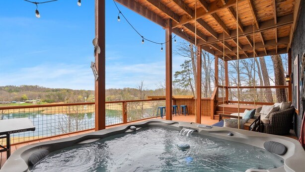 Ein Whirlpool mit Holzterrasse, Sitzgelegenheiten im Freien und Seeblick.