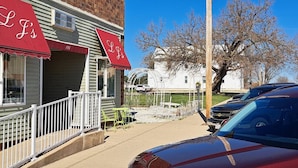 A storefront with awnings labeled "LJ's" and a red car parked in front. - Charming Magnolia Apartment (Magnolia)