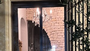 A room with a stone wall, a chandelier, and a wooden door. - Maison sur la Colline, Lagnes Proche de Gordes et Lisle sur la Sorgue (Lagnes)