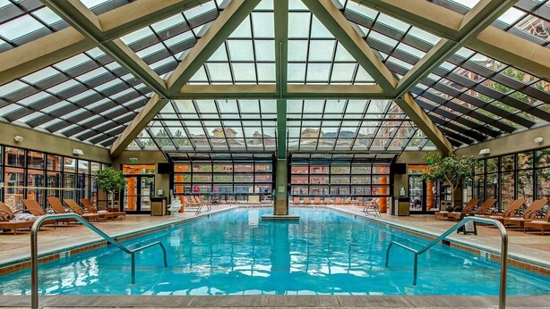 An indoor swimming pool with a glass ceiling, lounge chairs, and a sign indicating no diving. - Westgate 8th Floor Remodeled Luxury Studio Suite- Ski-In/Out, Full Kitchen (Park City)