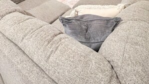 A living room with a grey sofa, a white sofa, and a patterned rug. There is a fireplace and a large window with curtains. - Beautiful, newly built 4 bedroom with garage (Yakima)