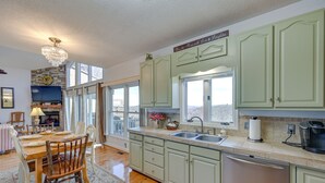 A kitchen with light green cabinets, a stainless steel dishwasher, and a large window. - Blue Ridge Mountain Resort Home with Amazing Views at Olde Beau -Mountain escape (Glade Valley)