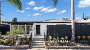 A modern house with a front yard, a wooden fence, and a palm tree. - Cozy, bright, and walk to Crown Point Park/Bay (San Diego)