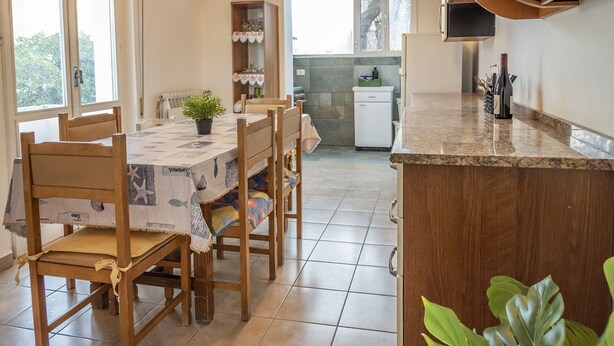 A dining area with a table and chairs, a small kitchen with a refrigerator, and a window with a view. - SE032 - Senigallia, comfortable four-room apartment 30 meters from the sea (Senigallia)