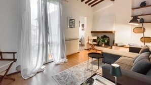 Un salon avec un canapé, une table basse, une lampe et une cheminée.