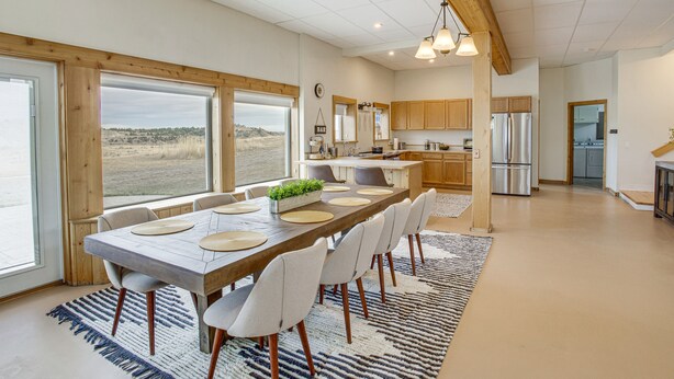 A modern kitchen with wooden cabinets, a large island, and a view of the landscape. - Secluded Montana Getaway w/ Fire Pit & Views! (Ryegate)