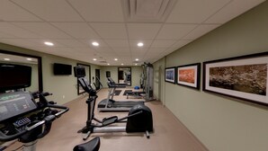 A fitness center with treadmills, elliptical machines, and a weight machine.