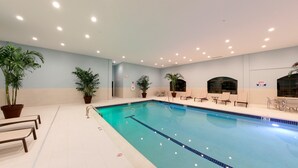 A swimming pool with lounge chairs and potted plants.