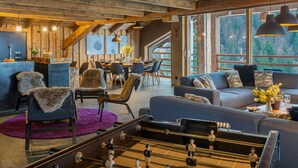 A cozy interior with a dining area, sofas, and a foosball table.