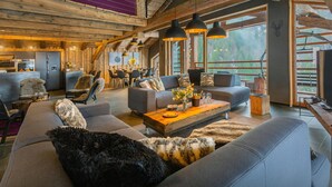 A rustic interior with a sofa, chairs, and a dining area.