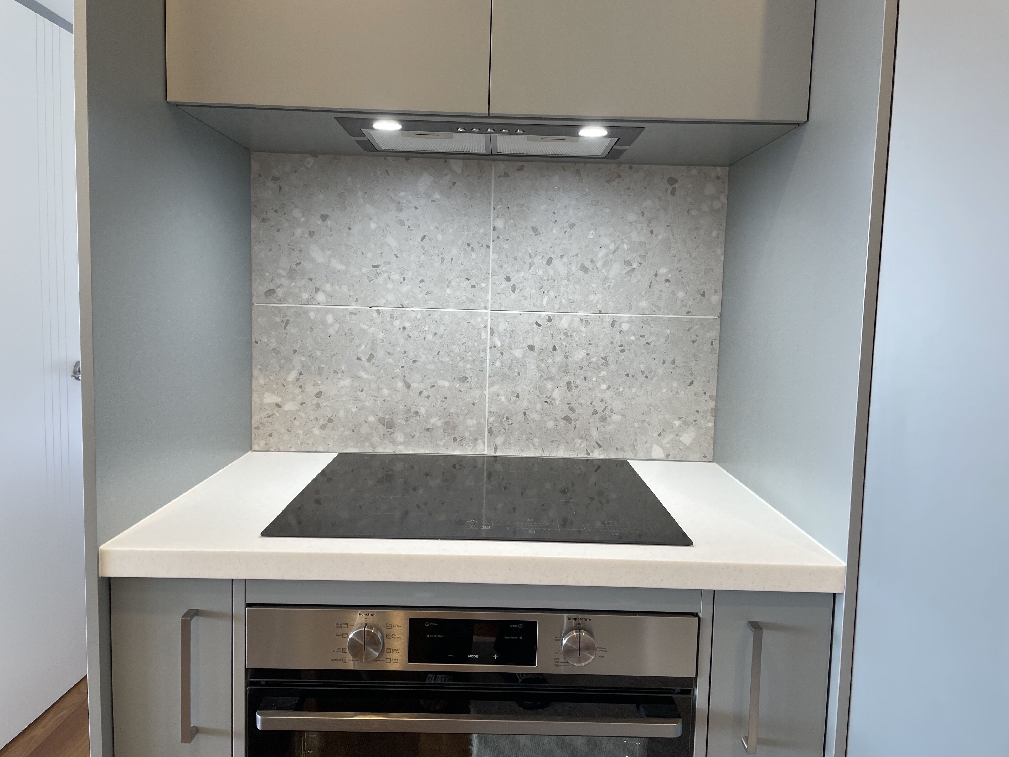 Una cocina con estufa integrada, horno y alacenas.