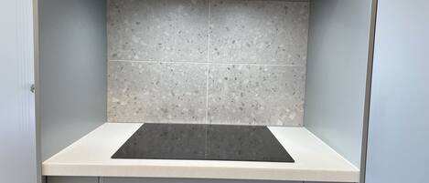 Una cocina con estufa integrada, horno y alacenas.
