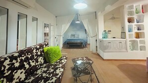 A modern room with a sofa, a small table, a bed, and a wall with decorative items.