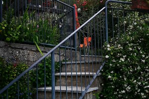 A staircase with metal railings, surrounded by greenery and flowers.