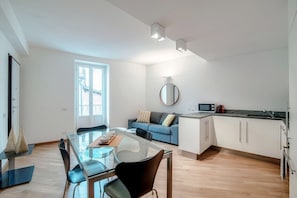 Un appartement moderne comprenant un coin repas, une cuisine et un espace de vie.