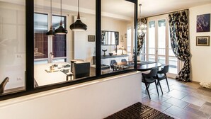A modern interior with a dining area, kitchen, and living space visible through a large window. - Blue Stay - My Home in Como (Riva)