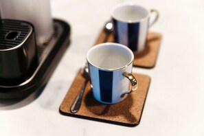 Duas chávenas de café sobre um prato com uma colher.