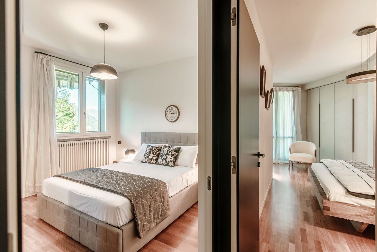 Une chambre à coucher avec un lit, une table de chevet et une fenêtre avec des rideaux.