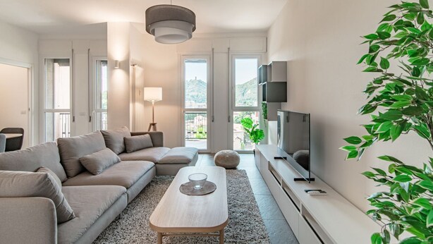 A modern living room with a sofa, a coffee table, a TV, and a large window. - Friends & Family Retreat - My Home In Como (Como)