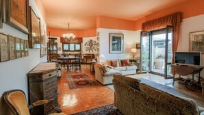 A spacious living room with a sofa, a dining area, and a kitchen. - Casa Panoramica - My Home In Como (Como)
