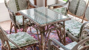 Wicker furniture with cushioned seats and a glass-top table, arranged around a patterned rug. - Fairy Tale - I Tigli - My Home In Como (Brunate)