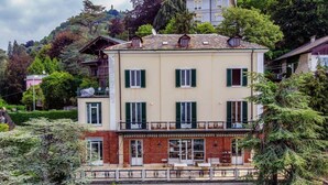 A multi-story building with a balcony, a door, and a window with shutters. - Fairy Tale - I Tigli - My Home In Como (Brunate)