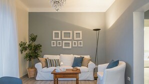 A living room with a sofa set, a coffee table, a floor lamp, and a potted plant. - Wonder View - My Home In Como (Como)