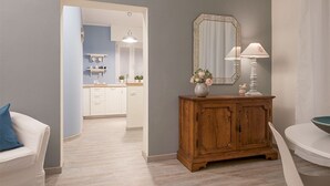 A room with a wooden cabinet, a mirror, and a vase with flowers. - Wonder View - My Home In Como (Como)
