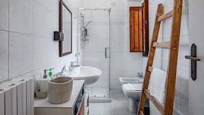 Une salle de bain moderne équipée d’une douche, d’un lavabo, de toilettes et d’une échelle en bois.