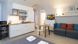 Una cocina moderna con armarios blancos, estufa integrada y comedor con mesa y sillas.